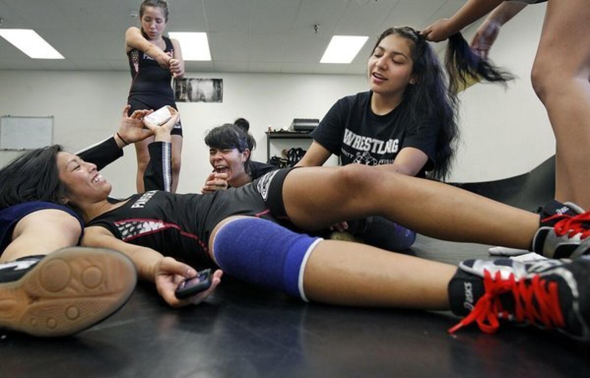 Panorama High wrestlers Marjorie Tabion, Coellet Rangel, Stephanie Gallegos, and Melissa Martinez, from left, hang out in the practice room before a home match. The girls revel in their bruises and gossip about prom.