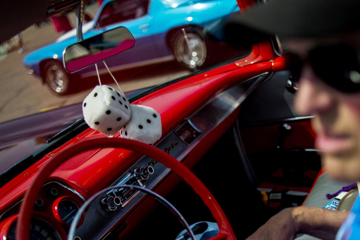 A vintage car with fuzzy dice.