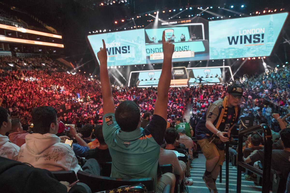 FILE - In this July 28, 2018, file photo, London Spitfire fan Rick Ybarra, of Plainfield, Ind., reacts after London won the second game against the Philadelphia Fusion during the Overwatch League Grand Finals competition at Barclays Center in New York. The Overwatch League took another step in its ambitious vision when franchises in Dallas and New York hosted season-opening matches last weekend. They were the first of 52 scheduled events on OWL’s home-and-away calendar requiring teams to visit host arenas for all 20 teams spanning Europe, North America and Asia. (AP Photo/Mary Altaffer, File)