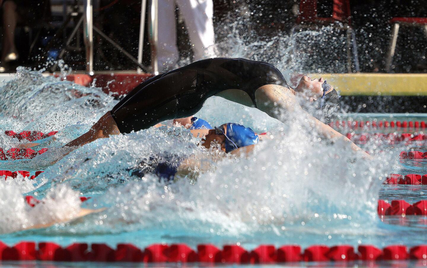 Burroughs' Maya Wilson springs out from the start as the rest of the pool are already in the water and smashes all swimmers winning the 100 backstroke and setting a school record in a dual Pacific League swim meet between Burbank and Burroughs at Burroughs High School on Wednesday, April 17, 2019.