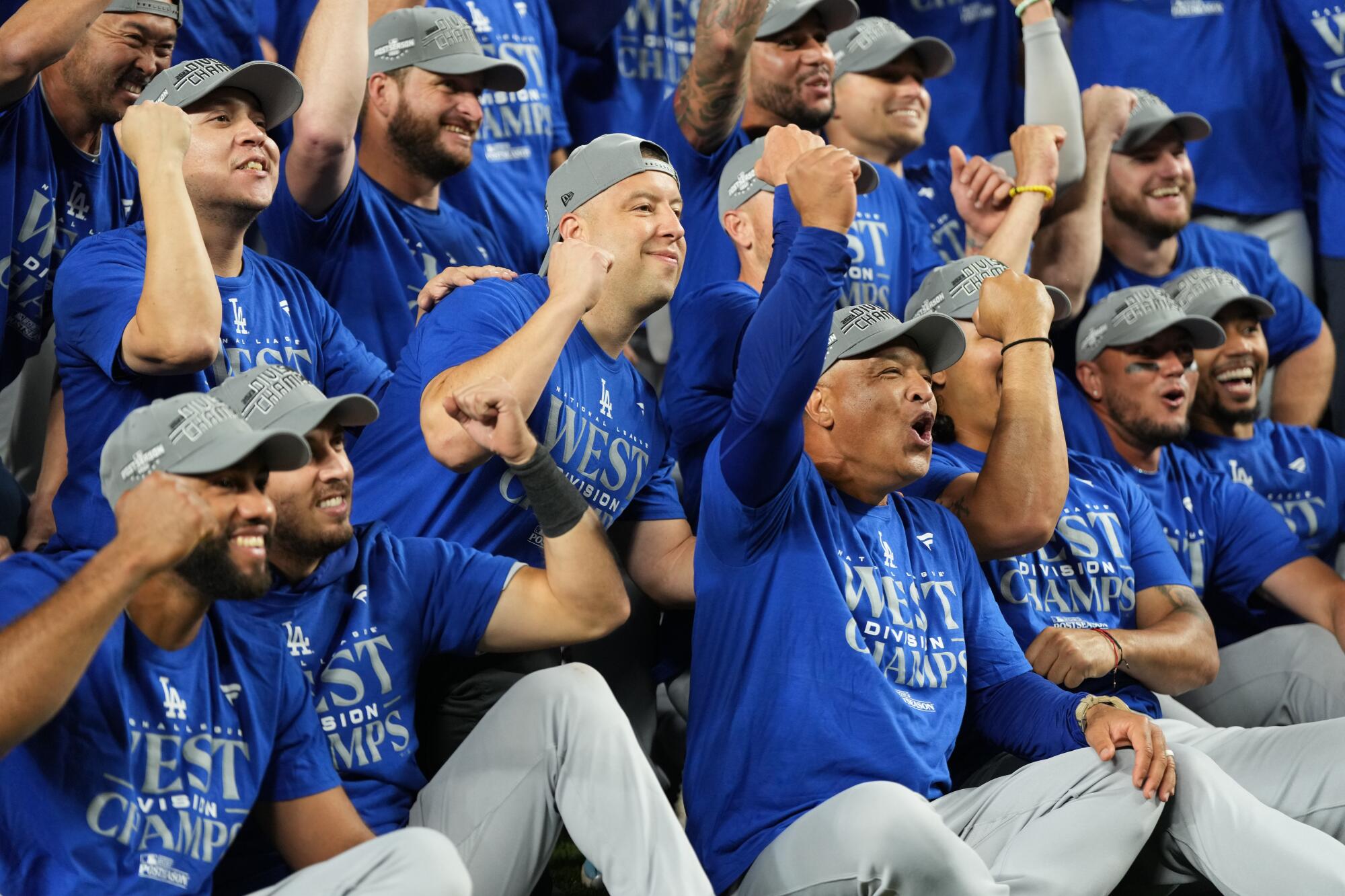 Dodgers players and coaches celebrate after clinching the National League West division title in a win over the Mariners.