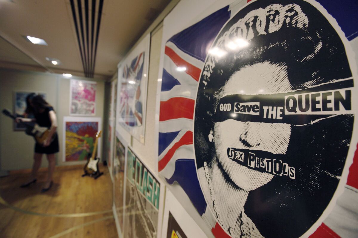 FILE - A promotional poster for the 1977 single God Save The Queen by the Sex Pistols on display, during a photo-op ahead of a rock and pop memorabilia auction, in central London, Thursday June 25, 2009. In Britain, there are several traditional elements to a royal anniversary: pageants, street parties, the Sex Pistols. Queen Elizabeth II and the Pistols have been linked since the punk pioneers released the song “God Save the Queen” in 1977 during the monarch’s Silver Jubilee. (AP Photo/Lefteris Pitarakis, File)
