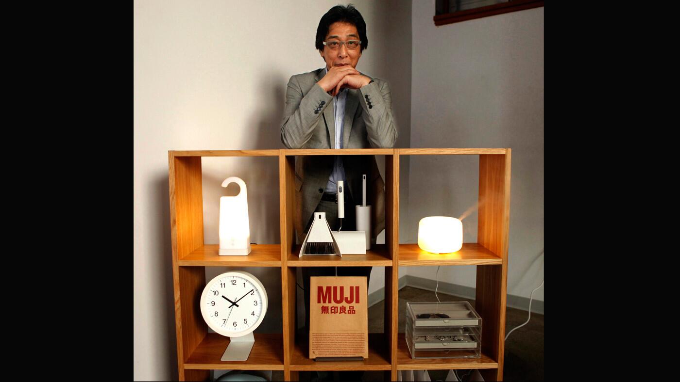 Masaaki Kanai, president of Japanese retailer Muji, poses with a selection of the store's minimalist products. A new Muji store is set to open in Santa Monica this month.