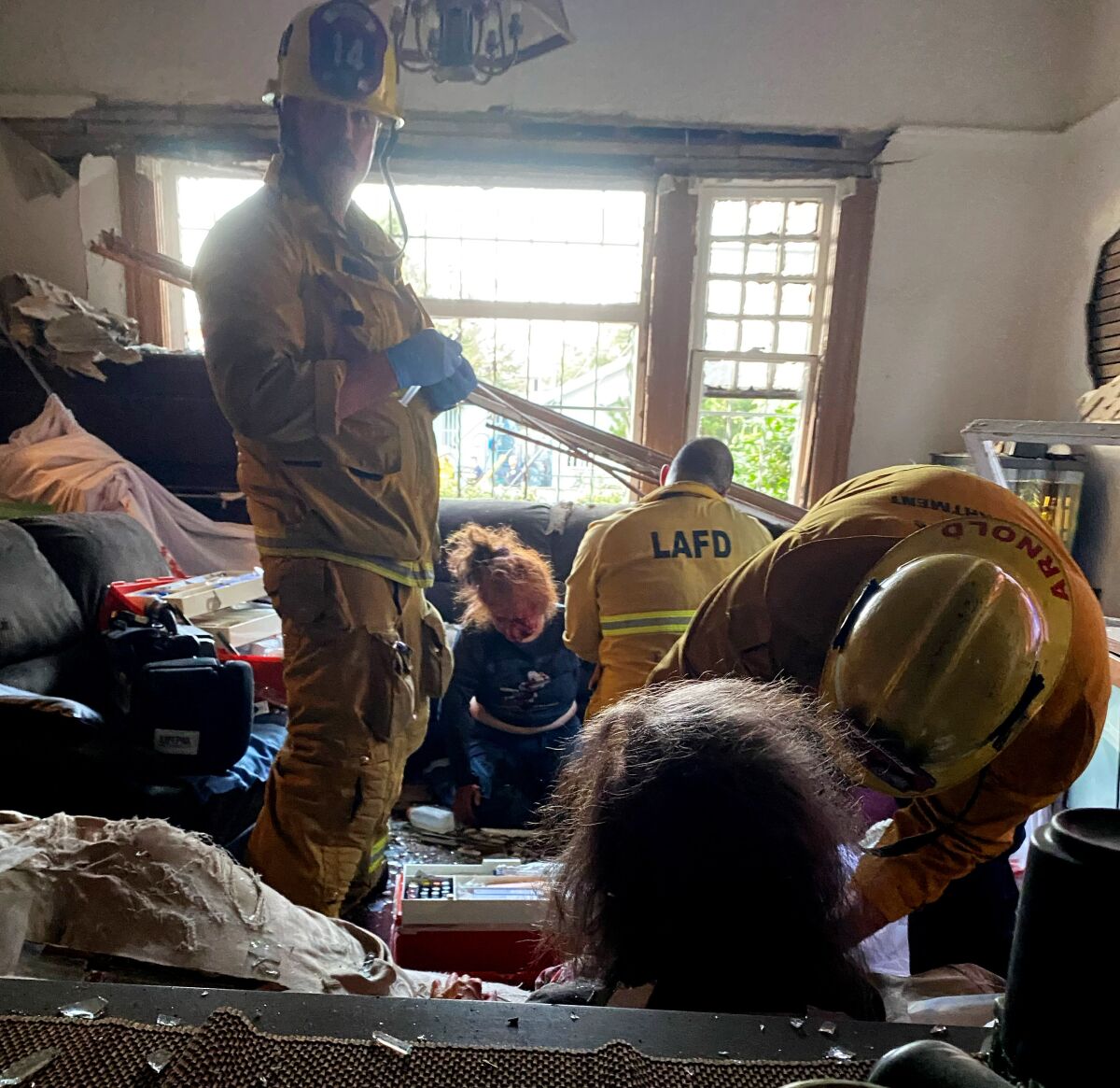 First responders treat individuals inside a home after the fireworks explosion in South L.A.