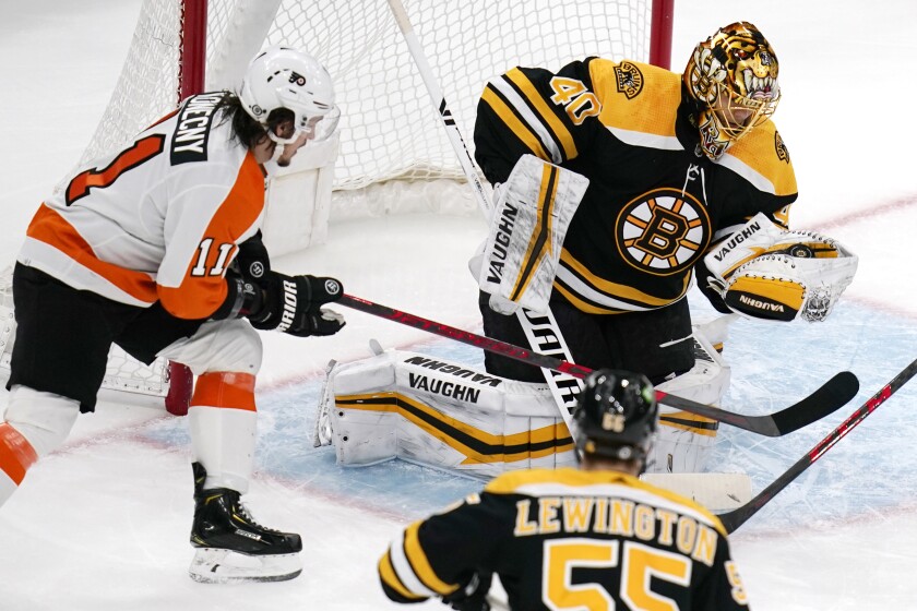 Boston Bruins goaltender Tuukka Rask (40) gloves the puck for a save as Philadelphia Flyers right wing Travis Konecny (11) waits for a rebound during the first period of an NHL hockey game, Thursday, Jan. 13, 2022, in Boston. (AP Photo/Charles Krupa)