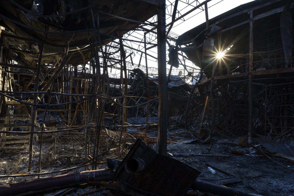 Rayos de sol atraviesan estructuras calcinadas en una zona bombardeada del mercado de Barabashovo, 