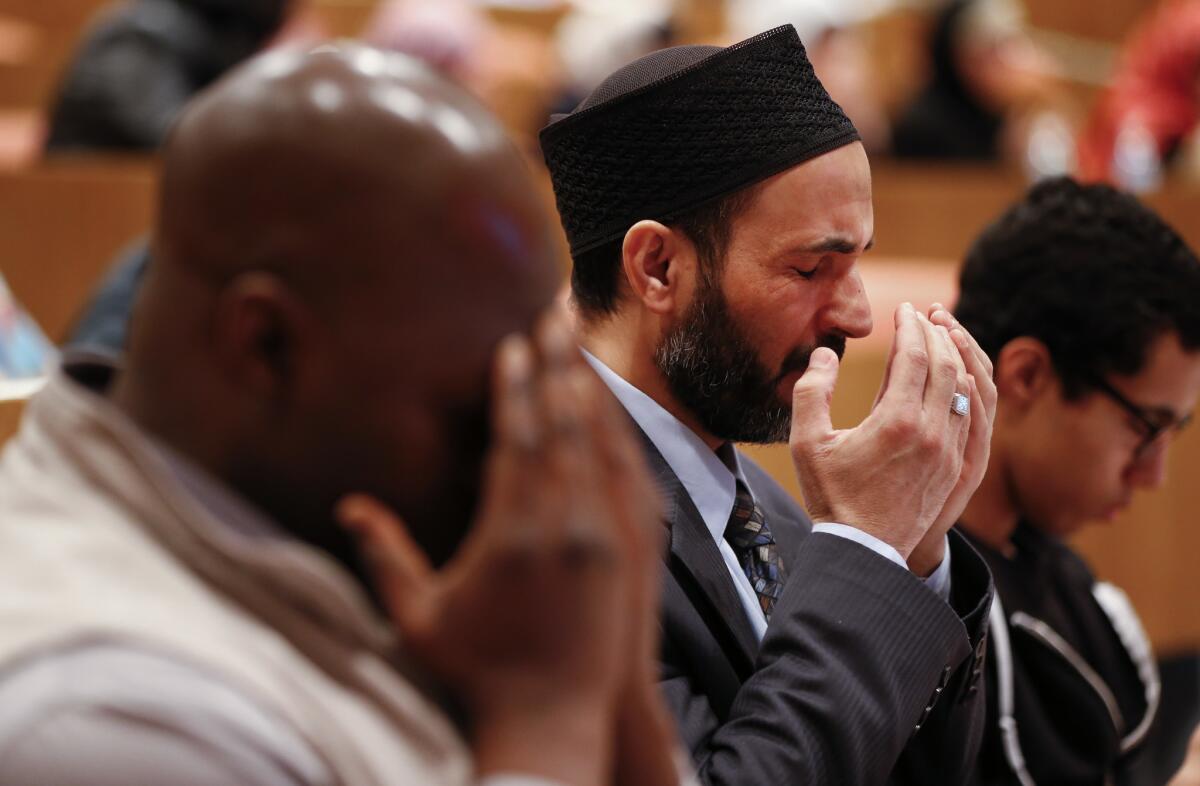 Members of the audience at an Ahmadiyya Muslim Community of Metro Detroit symposium in Dearborn, Mich., pray during a moment of silence on March 23 following the attacks in Brussels.