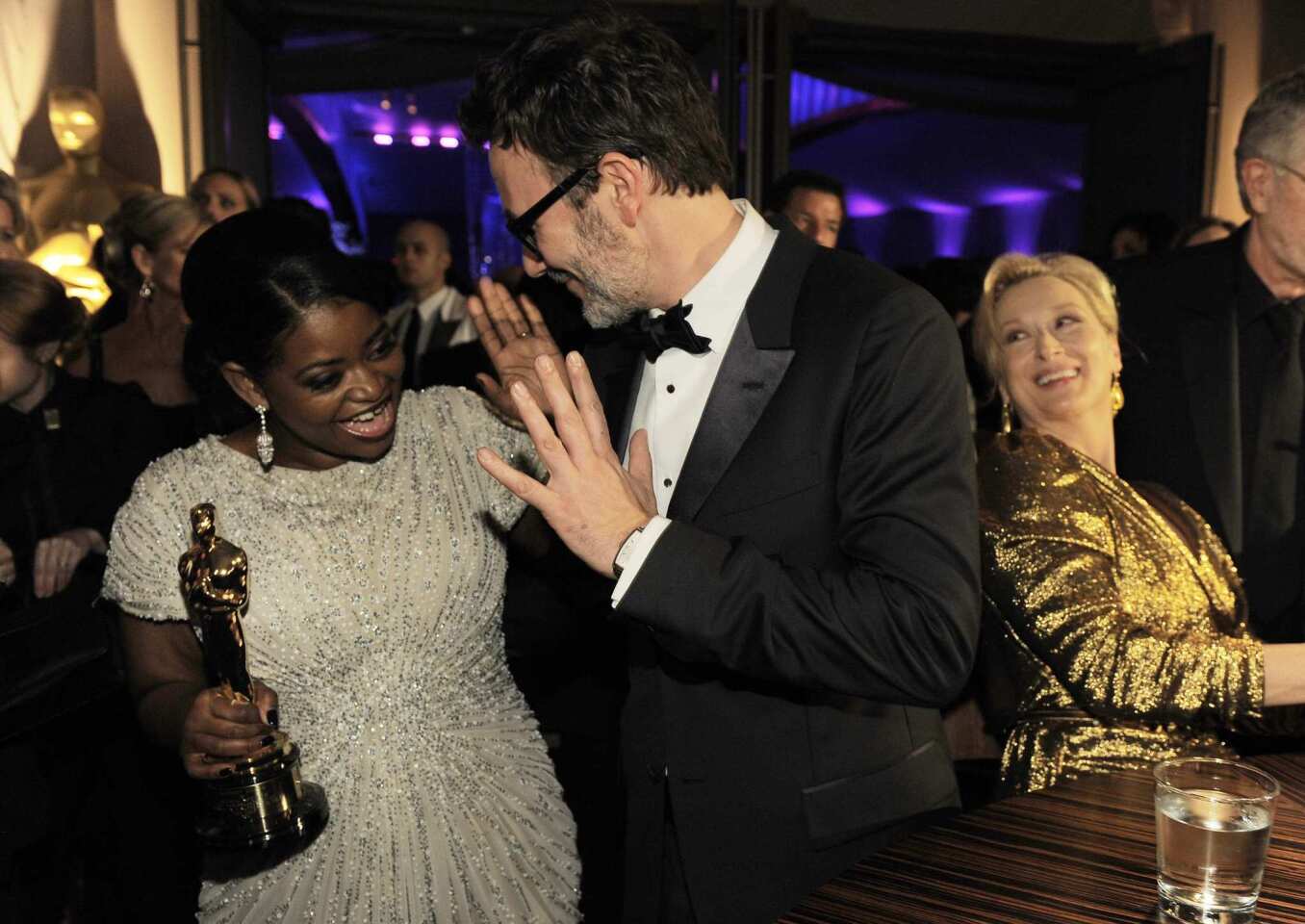 Supporting actress Spencer has a high-five moment with best director Hazanavicius as the lead actress winner, Meryl Streep, enjoys the levity.
