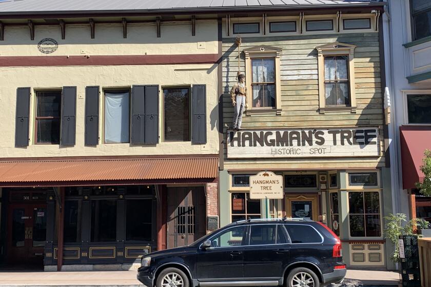 "George," a life-sized mannequin, hangs from the side of a building in downtown Placerville in July 2020.