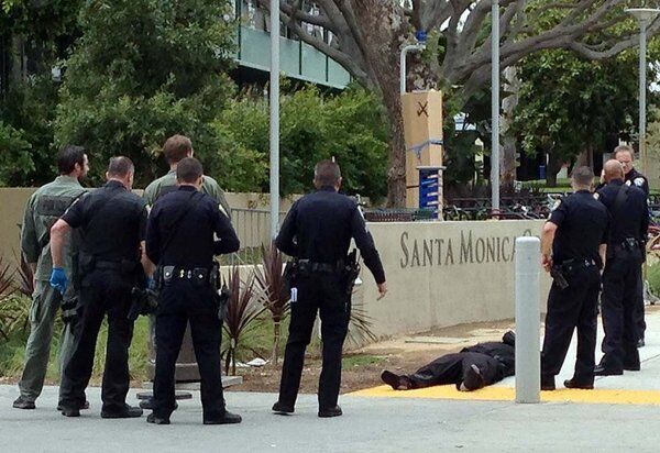 Police officers surround a body on the Santa Monica College campus.