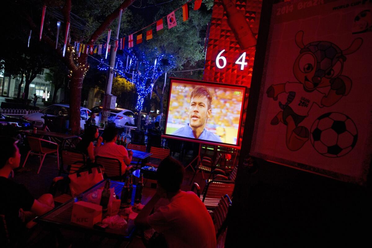 Brazilian soccer star Neymar appears on the screen at a Beijing bar during the opening match of the 2014 World Cup.