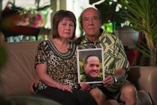 Verdell and William Haleck of Utah hold a photo of their son Sheldon, who died after an encounter with Honolulu police.