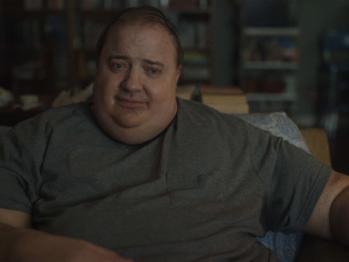 An obese man sits in a chair in a scene from "The Whale"