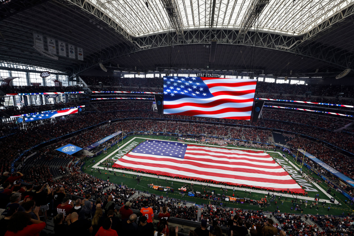 An American Flag is displayed on the field at AT&T Stadium.