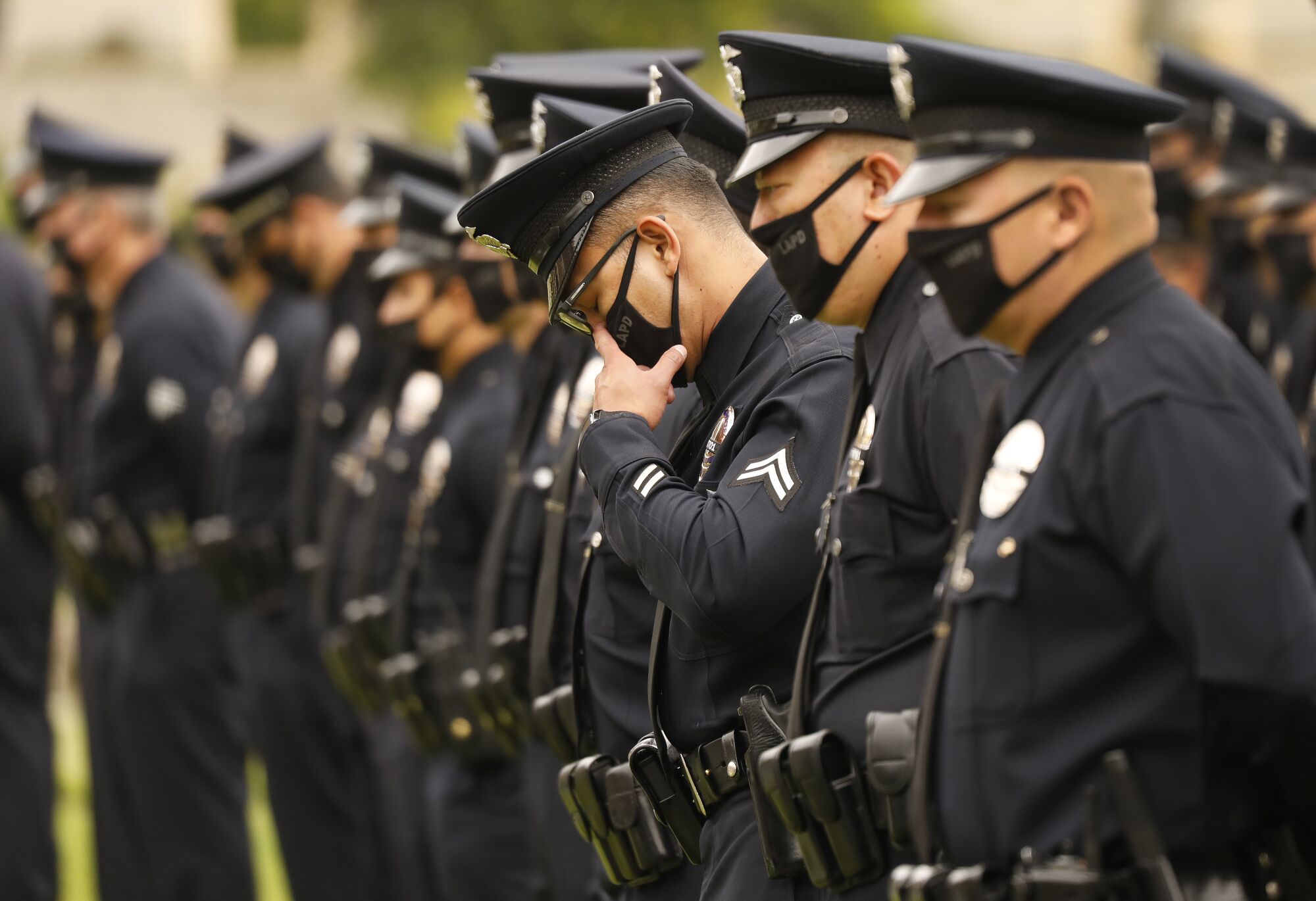 An officer wipes a tear during the service.