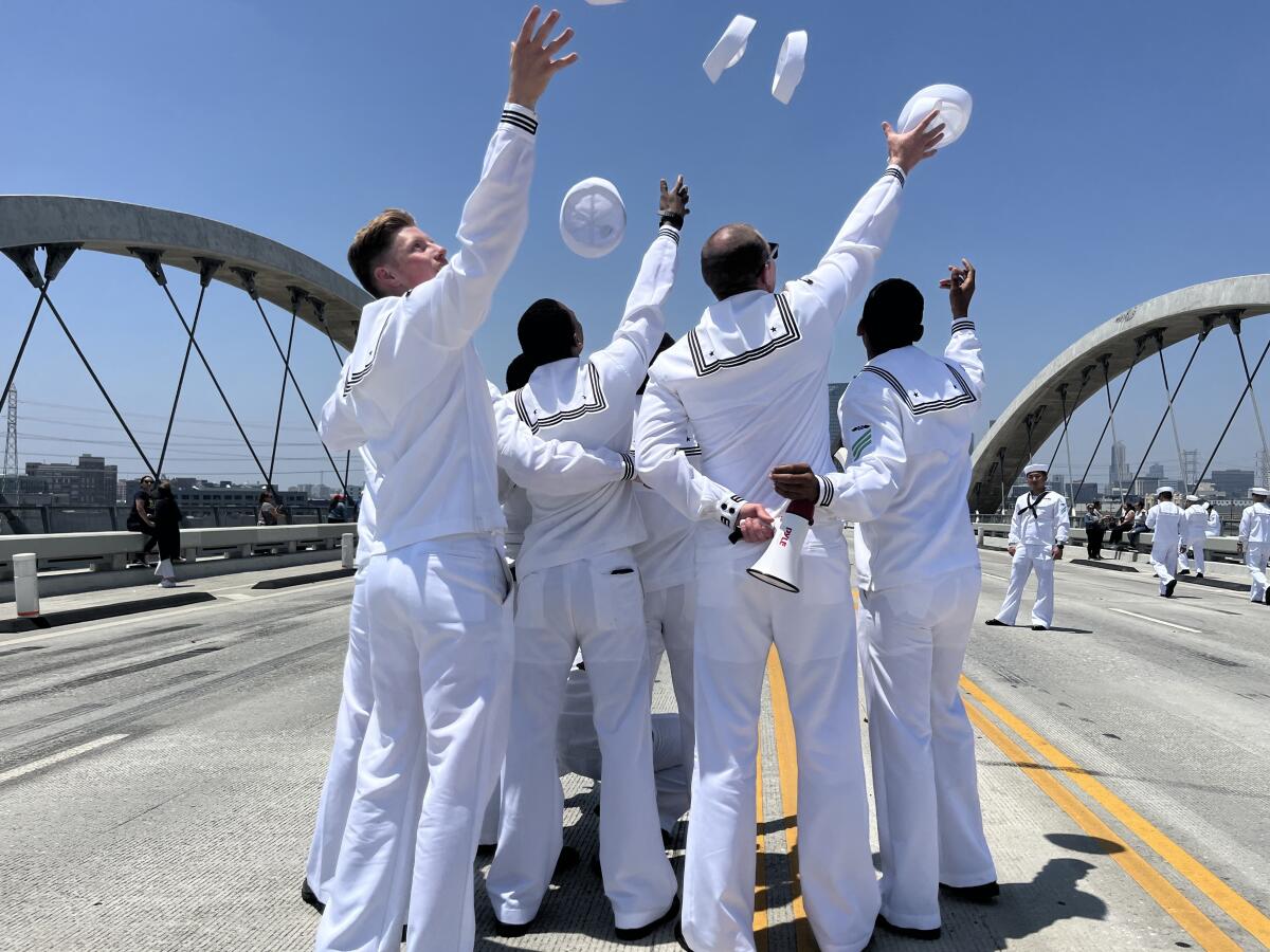 The man in the white uniform threw his sailor hat into the air.