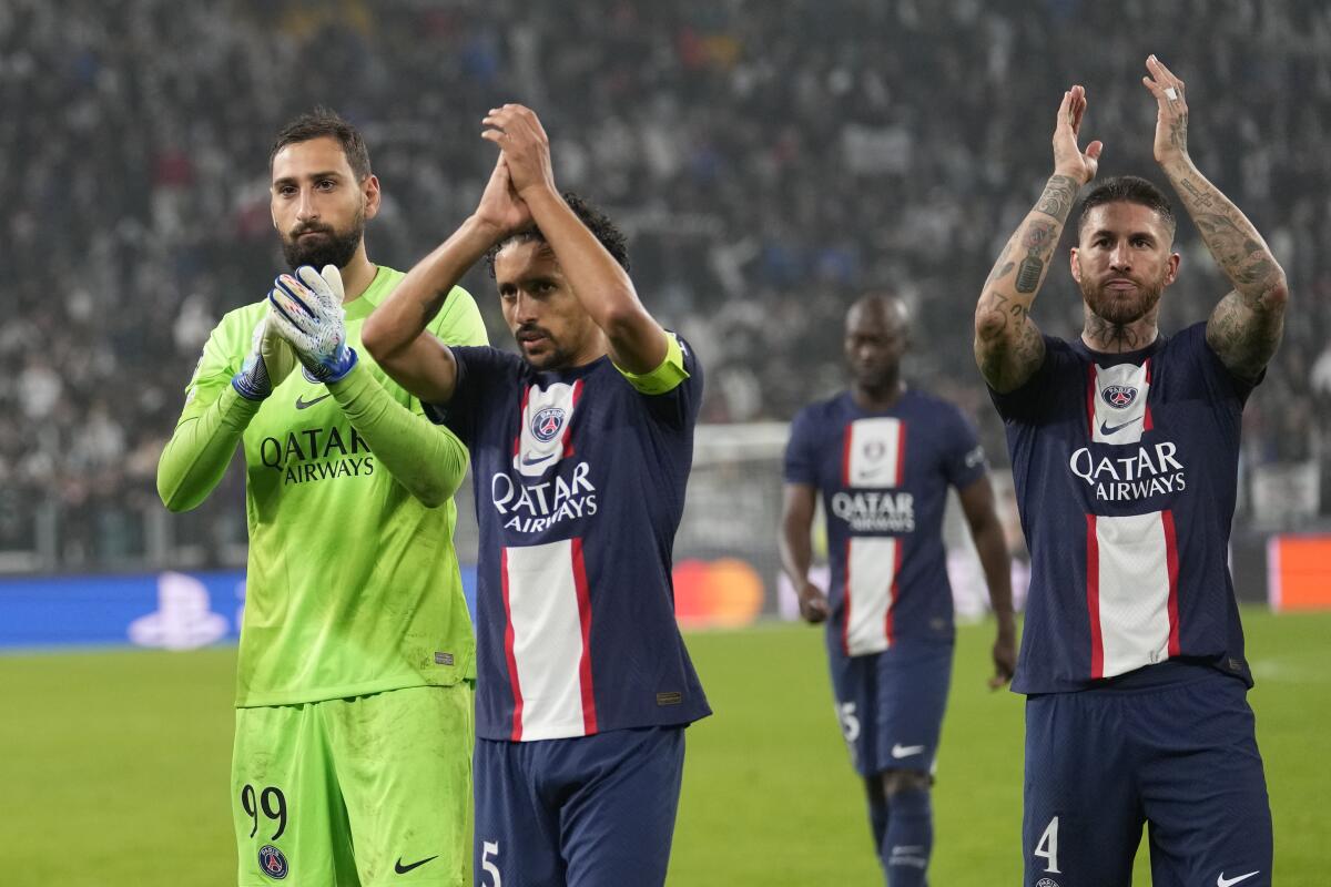 PSG's Sergio Ramos, right, PSG's goalkeeper Gianluigi Donnarumma, left, and PSG's Marquinhos applaud fans at the end of the Champions League group H soccer match between Juventus and Paris Saint Germain at the Allianz stadium in Turin, Italy, Wednesday, Nov. 2, 2022. (AP Photo/Antonio Calanni)