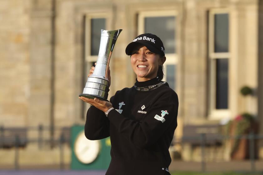 New Zealand's Lydia Ko poses with the trophy after winning the Women's British Open in St. Andrews, Scotland, on Sunday.