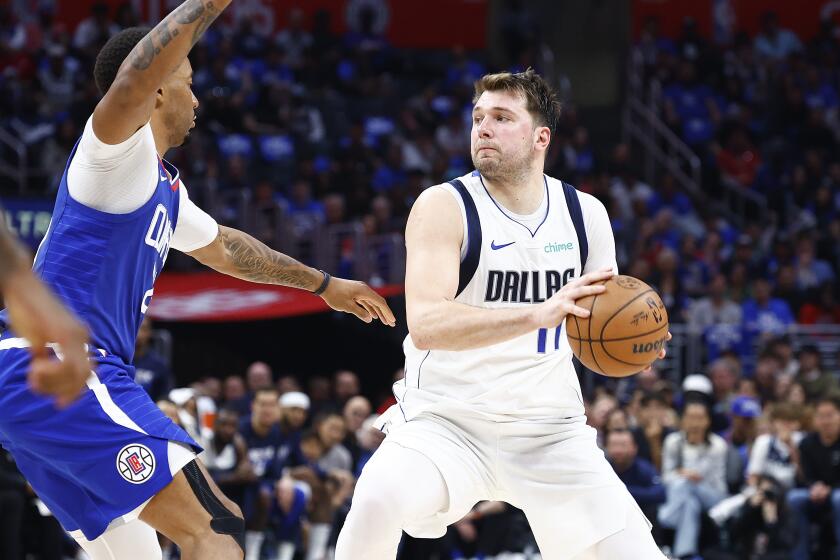 Dallas Mavericks star Luka Doncic, right, controls the ball during the Clippers' Game 1 win at Crypto.com Arena on Sunday.