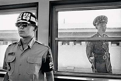 A South Korean soldier, far left, and his North Korean counterpart at the Military Demarcation Line that runs through the DMZ at Panmunjom. After the signing of the Armistice Agreement, Panmunjom was designated a Joint Security Area and the headquarters of the Military Armistice Commission under the shared management of the United Nations Command and North Korea. The joint discussions that take place there have helped keep a fragile peace for 50 years.
