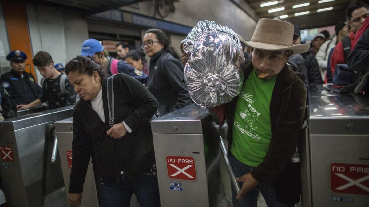 A Central American migrant passes through a subway turnstile after leaving the temporary shelter at the Jesus Martinez stadium in Mexico City.