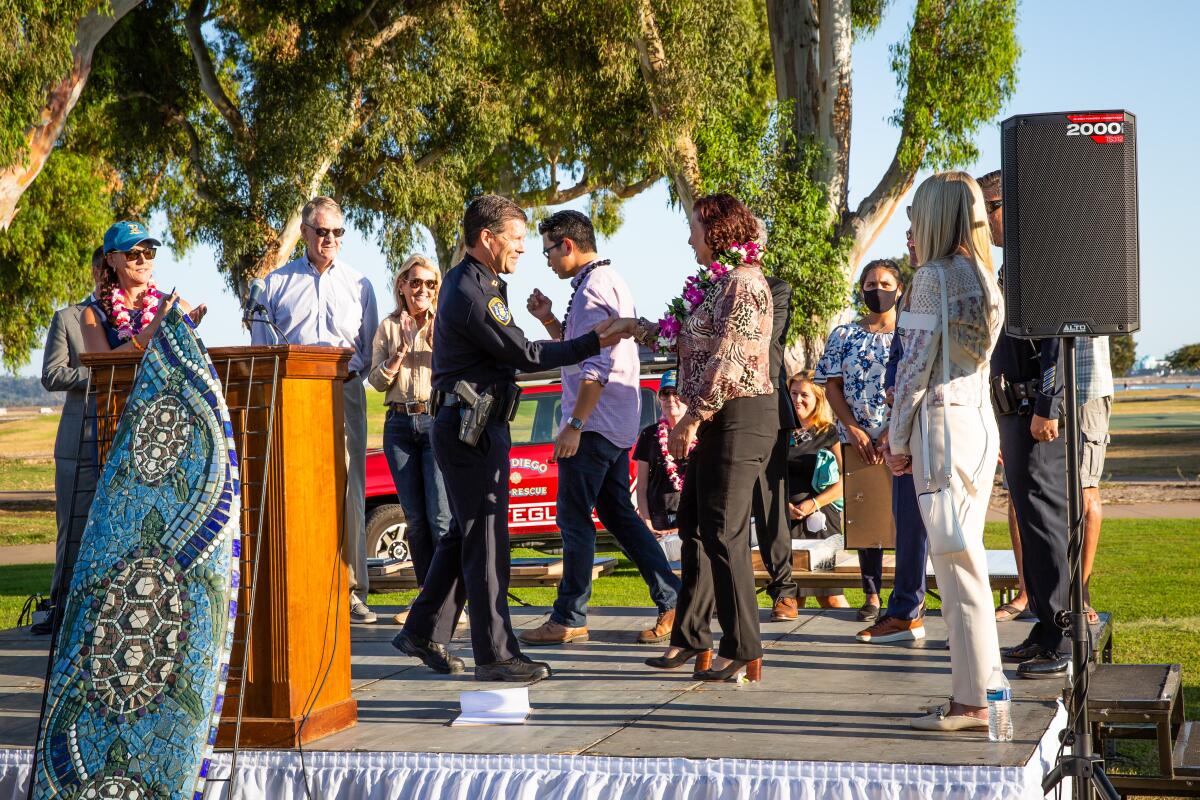 Police Northern Division Commander Capt. Scott Wahl shakes hands with PAESAN honoree Det. Julie Adams.