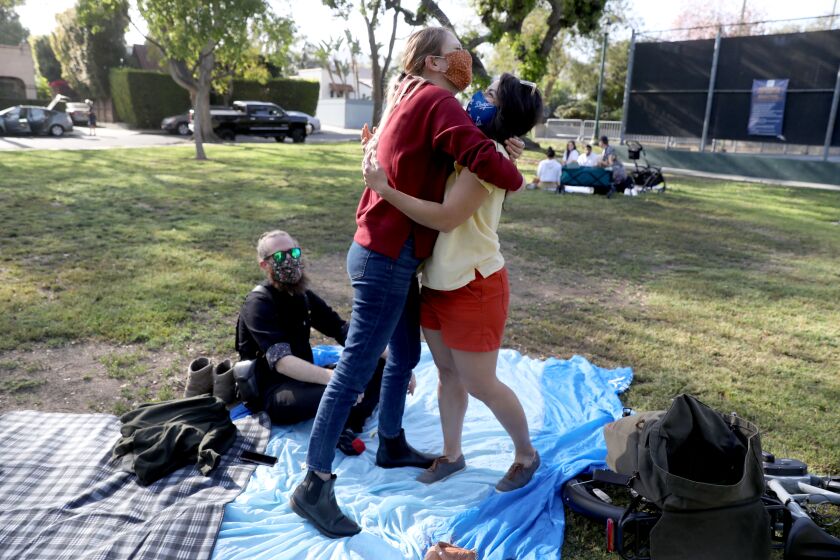 Jessica Holzer, 35, of West Hollywood, hugs friend Madeline Brozen, 35, of Los Angeles, for the first time since pandemic.