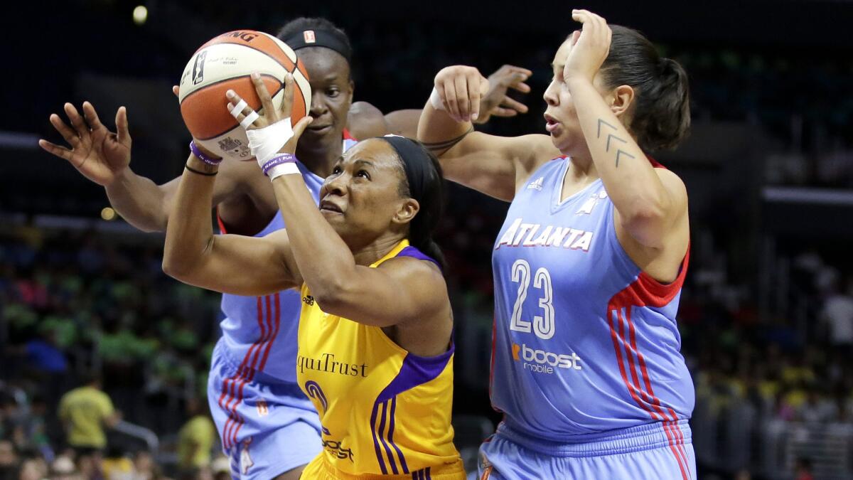 Sparks guard Temeka Johnson drives between Atlanta's Shoni Schimmel (23) and Aneika Henry in the first half of their game Thursday afternoon at Staples Center.