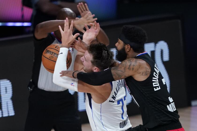 Dallas Mavericks fo Luka Doncic (77) is fouled by Los Angeles Clippers' Marcus Morris Sr. 