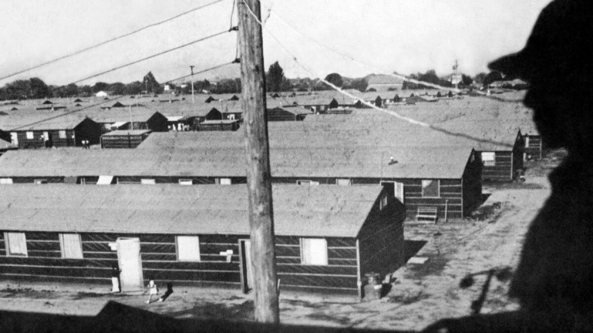 In this undated photo provided by the War Relocation Authority, armed guard overlooks barracks built in the middle of the racetrack at the Fresno Fairgrounds in Fresno. This was the first stop for detainees before they were sent to permanent internment camps.