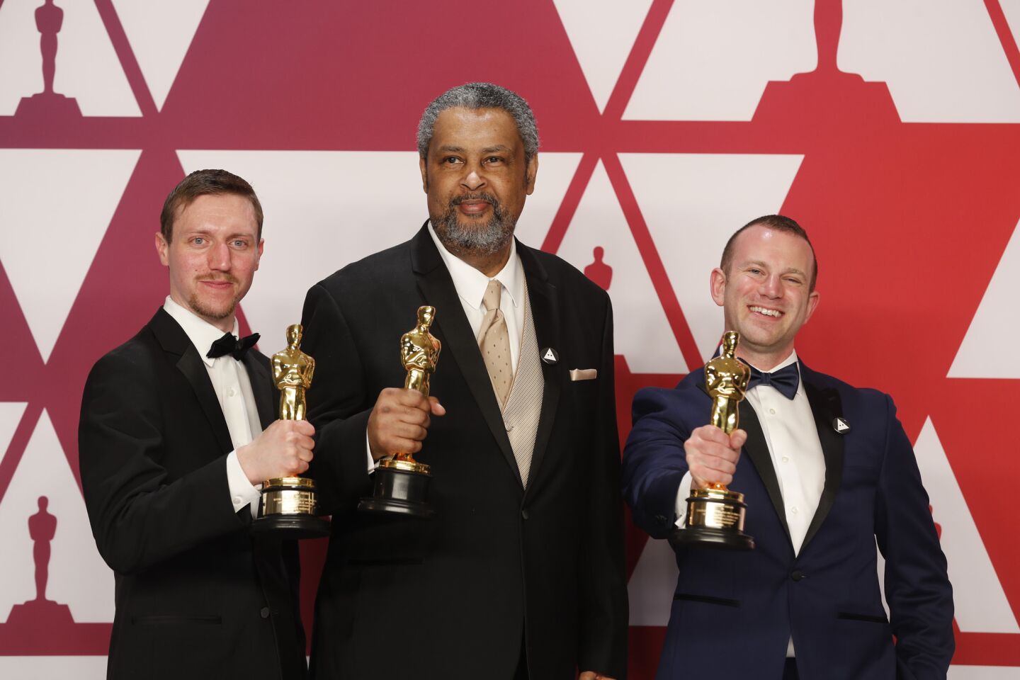Producers David Rabinowitz, left, Kevin Willmott and Charlie Wachtel pose with the adapted screenplay award for "BlacKkKlansman."