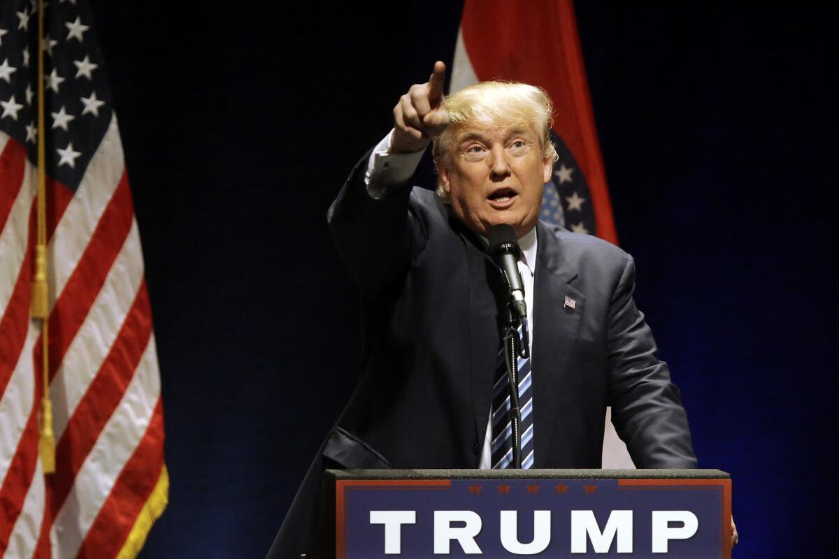 Republican presidential candidate Donald Trump points to balcony where protesters were causing a disturbance during a campaign rally Friday in St. Louis.