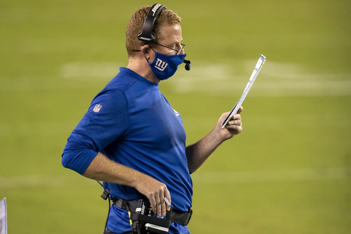 New York Giants offensive coordinator Jason Garrett reads from a play chart during a game against the Philadelphia Eagles.