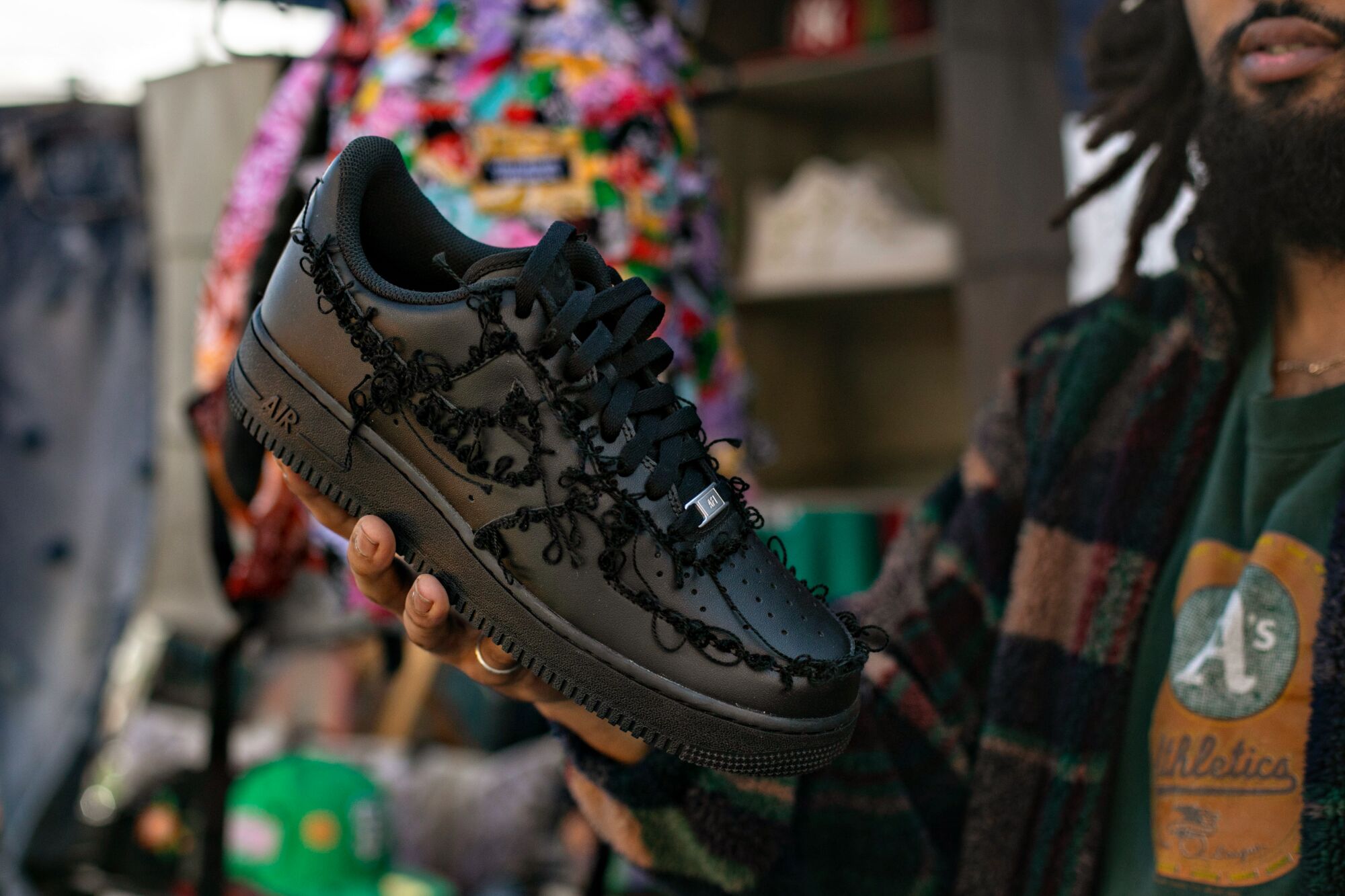 A hand holding a black shoe
