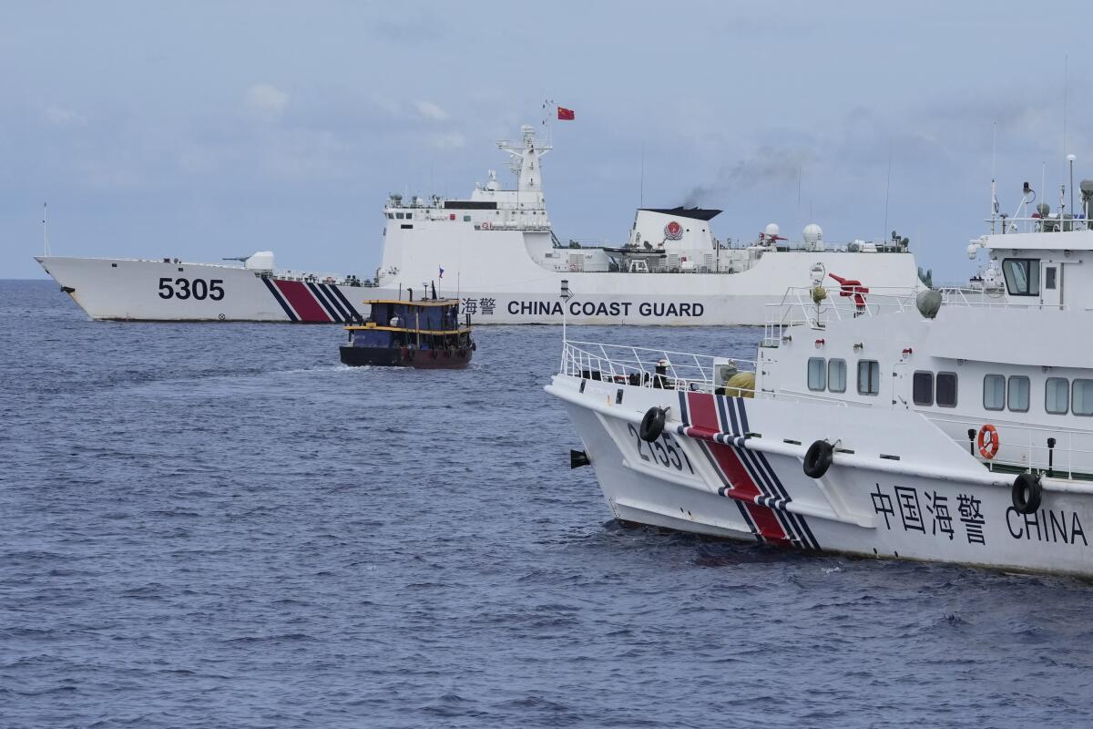 Philippine supply boat maneuvers through line of Chinese coast guard ships