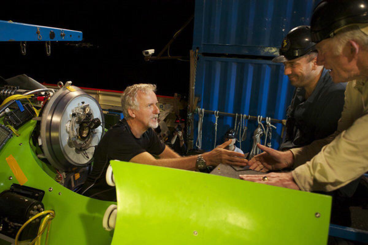 James Cameron gets a handshake from Navy Capt. Don Walsh before the hatch of the Deepsea Challenger submarine is closed and Cameron's solo voyage to the deepest part of the ocean begins on March 25, 2012.
