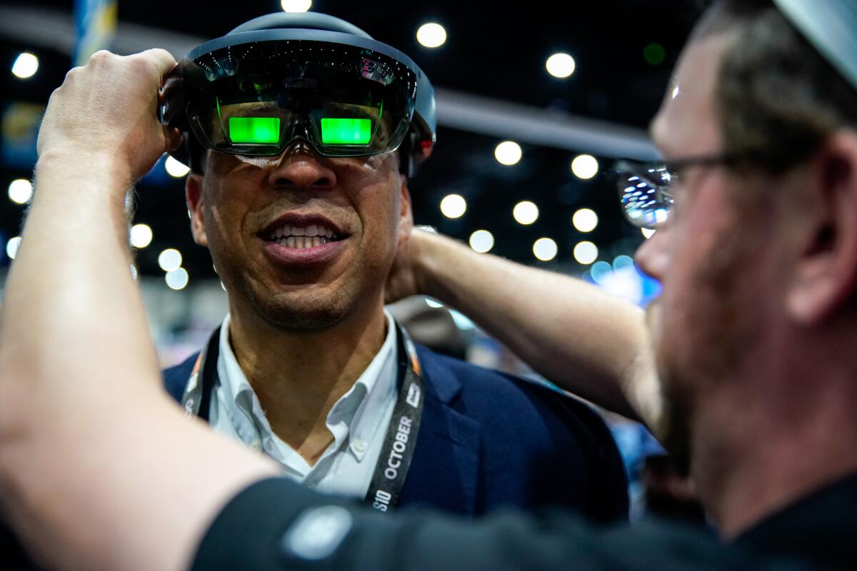Presidential candidate Sen. Cory Booker (D-N.J.) looks through a headset at the NASA booth at the Comic-Con International exhibition hall at the San Diego Convention Center on Friday.