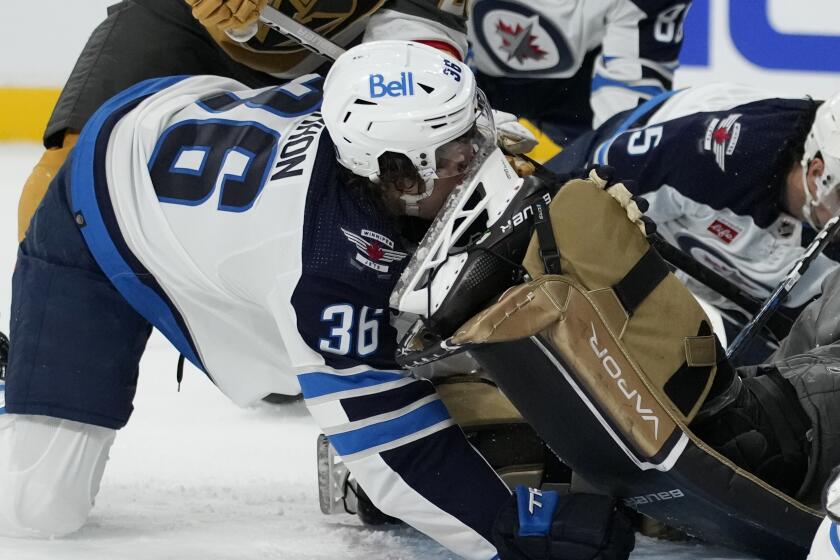 Winnipeg Jets center Morgan Barron (36) gets his face cut on the skate of Vegas Golden Knights goaltender Laurent Brossoit (39) during the first period of Game 1 of an NHL hockey Stanley Cup first-round playoff series Tuesday, April 18, 2023, in Las Vegas. (AP Photo/John Locher)