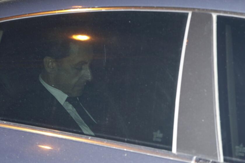 Former French President Nicolas Sarkozy on Wendesday leaves the Paris building where he was questioned by financial crimes investigators.