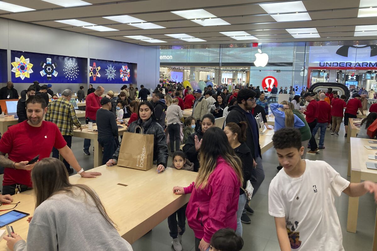File - People shop at an Apple store in the Westfield Garden State Plaza mall in Paramus, New Jersey, on Saturday, December 17, 2022. On Friday, the Commerce Department issues its February report on consumer spending. (AP Photo/Ted Shaffrey, File)