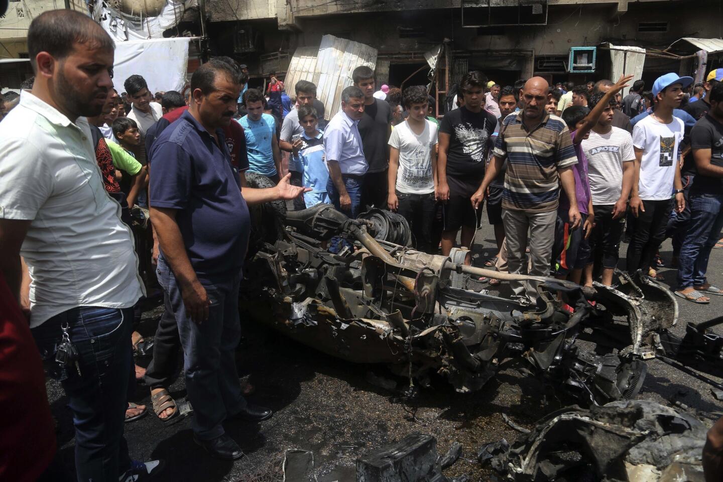 People inspect the damage after a car bomb exploded at a crowded outdoor market in Sadr City, Iraq, on May 11, 2016.