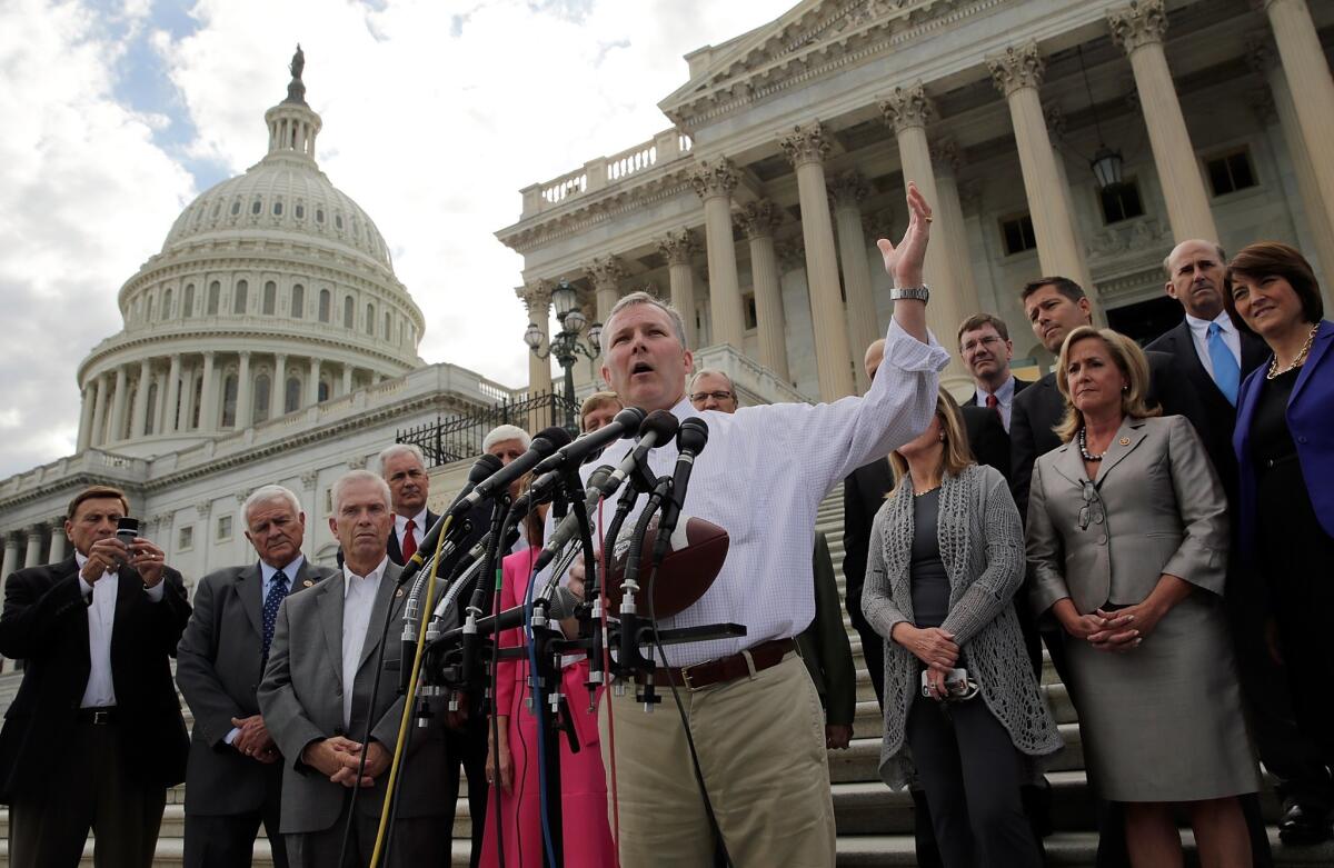 Rep. Tim Griffin (R-AR), holding a football to illustrate that he believes Democrats are "running out the clock", joins members of the House Republican caucus on the steps of the U.S. Senate to protest the Senate not being in session Sunday to work on legislation to avert a government shutdown.