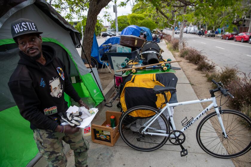LOS ANGELES, CA - JUNE 07: Nathaniel Prenters, 44, gathers his belongings before clean-up by Los Angeles City sanitation of an encampment along 200 block of S. Venice Blvd., Los Angeles, CA. (Irfan Khan / Los Angeles Times)