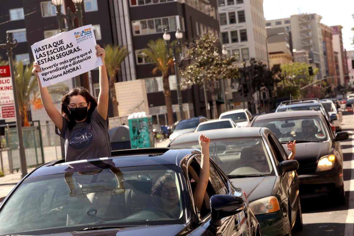 A Garfield High School student holds a sign calling for continued distance learning for now.