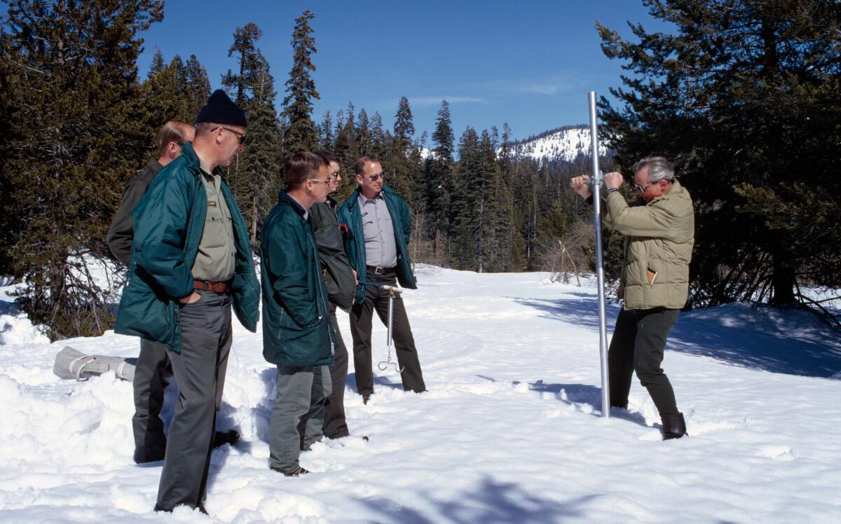 Ned Peterson, right, of the California Department of Water Resources demonstrates how to use the snowpack sampler during a snow survey class in 1969. (California Department of Water Resources)