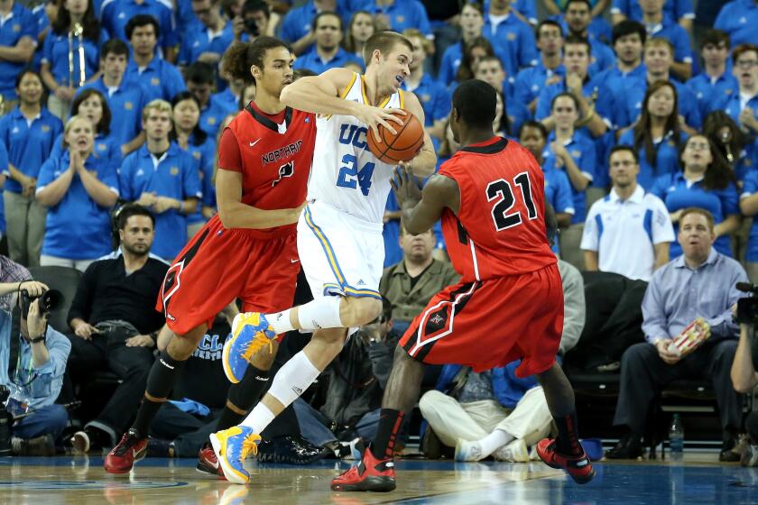 UCLA forward Travis Wear drives against Cal State Northridge's Tre Hale-Edmerson and Stephen Maxwell (21) at Pauley Pavilion.