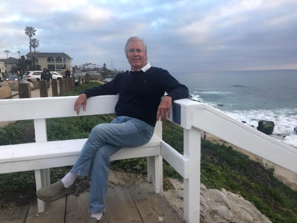 La Jolla resident Joseph McGoldrick sits at the top of the Windansea staircase he repainted.