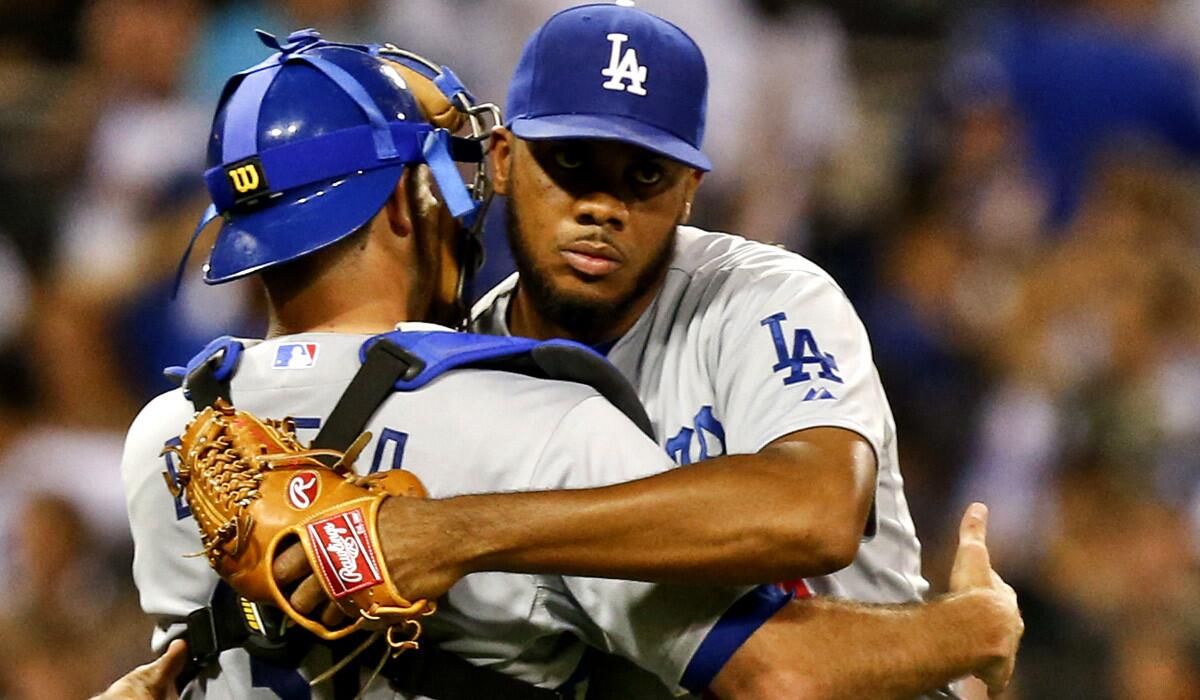 Dodgers closer Kenley Jansen gets a hug from catcher Drew Butera after closing out the Dodgers' 4-2 victory over the San Diego Padres on Saturday night at Petco Park.