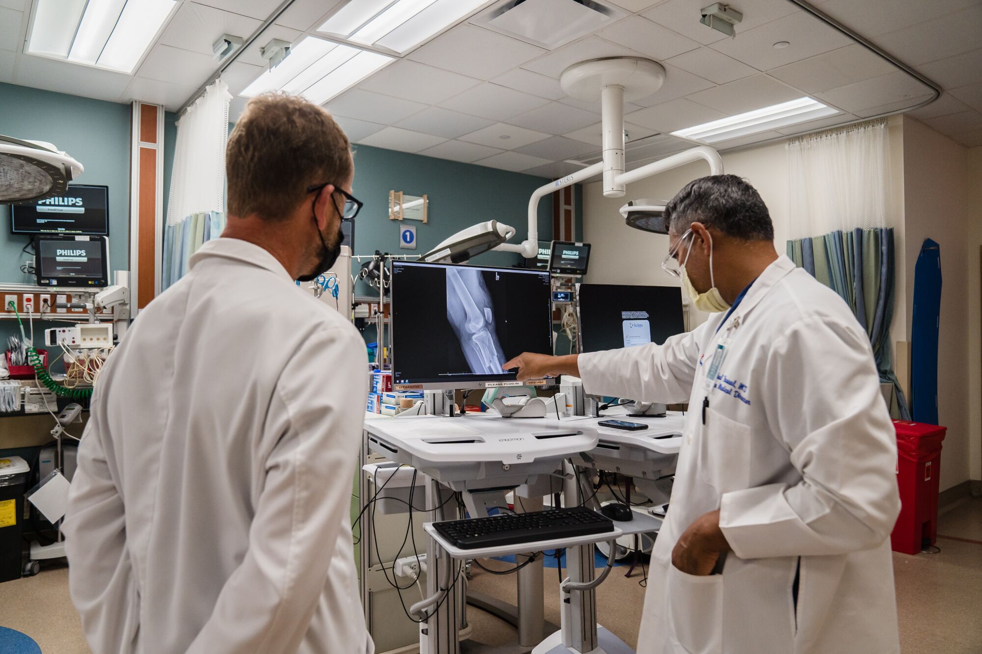 Chief of Trauma Surgery Dr. Vishal Bansal (right) and Orthopedic Trauma Surgeon Dr. Kevin Kuhn (left) look at an X-ray