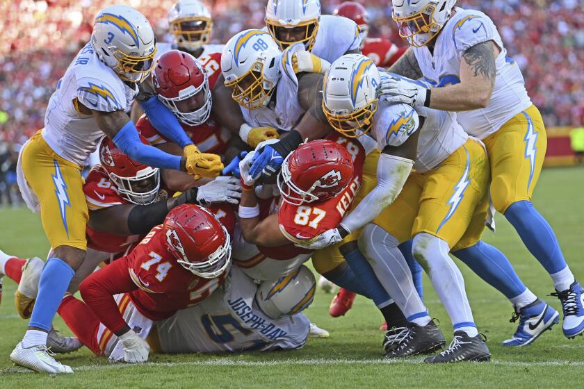 Chiefs tight end Travis Kelce (87) carries Chargers defenders into the end zone on a touchdown reception.